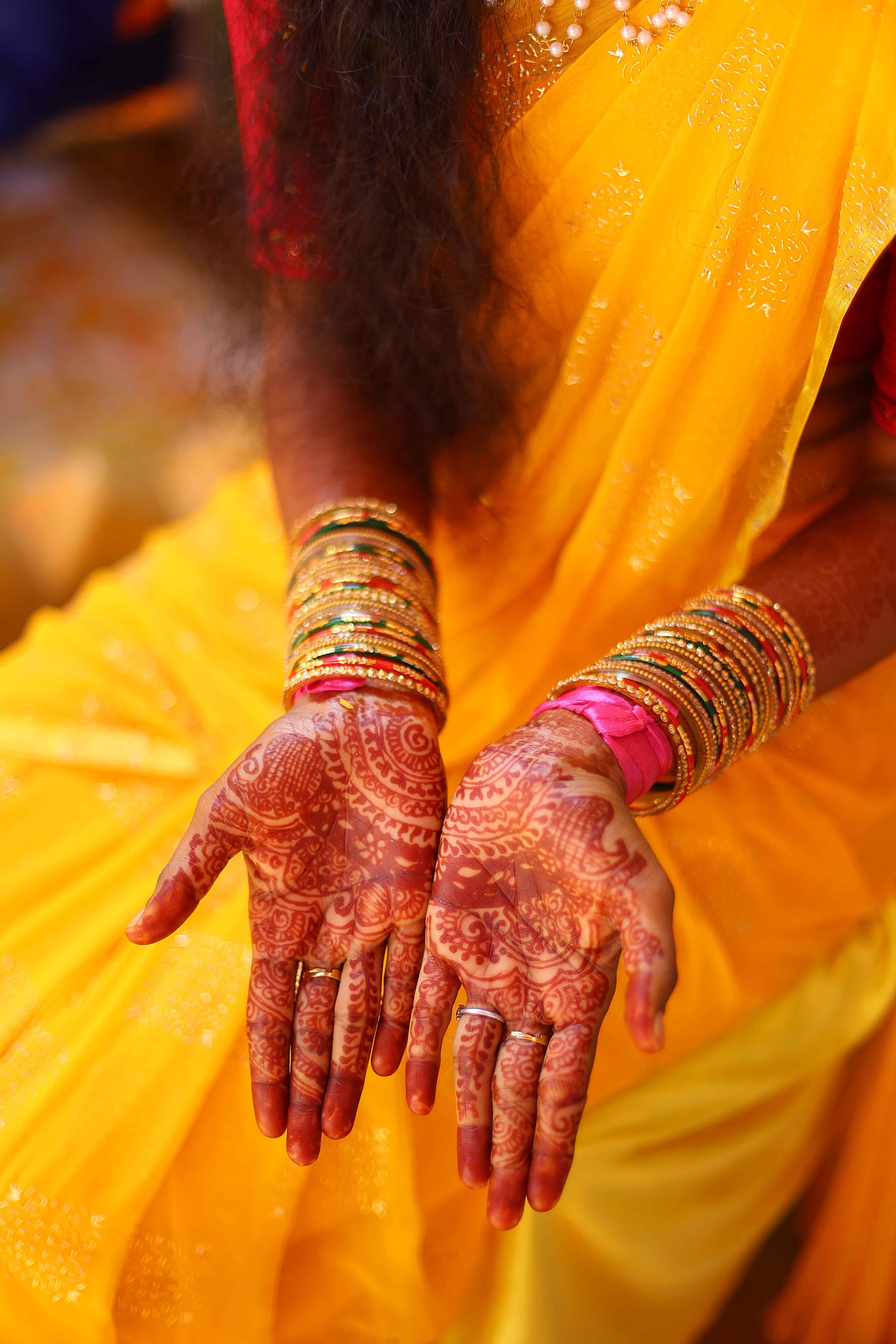 Close-up of Eswari’s hands beautifully adorned during the haldi ritual