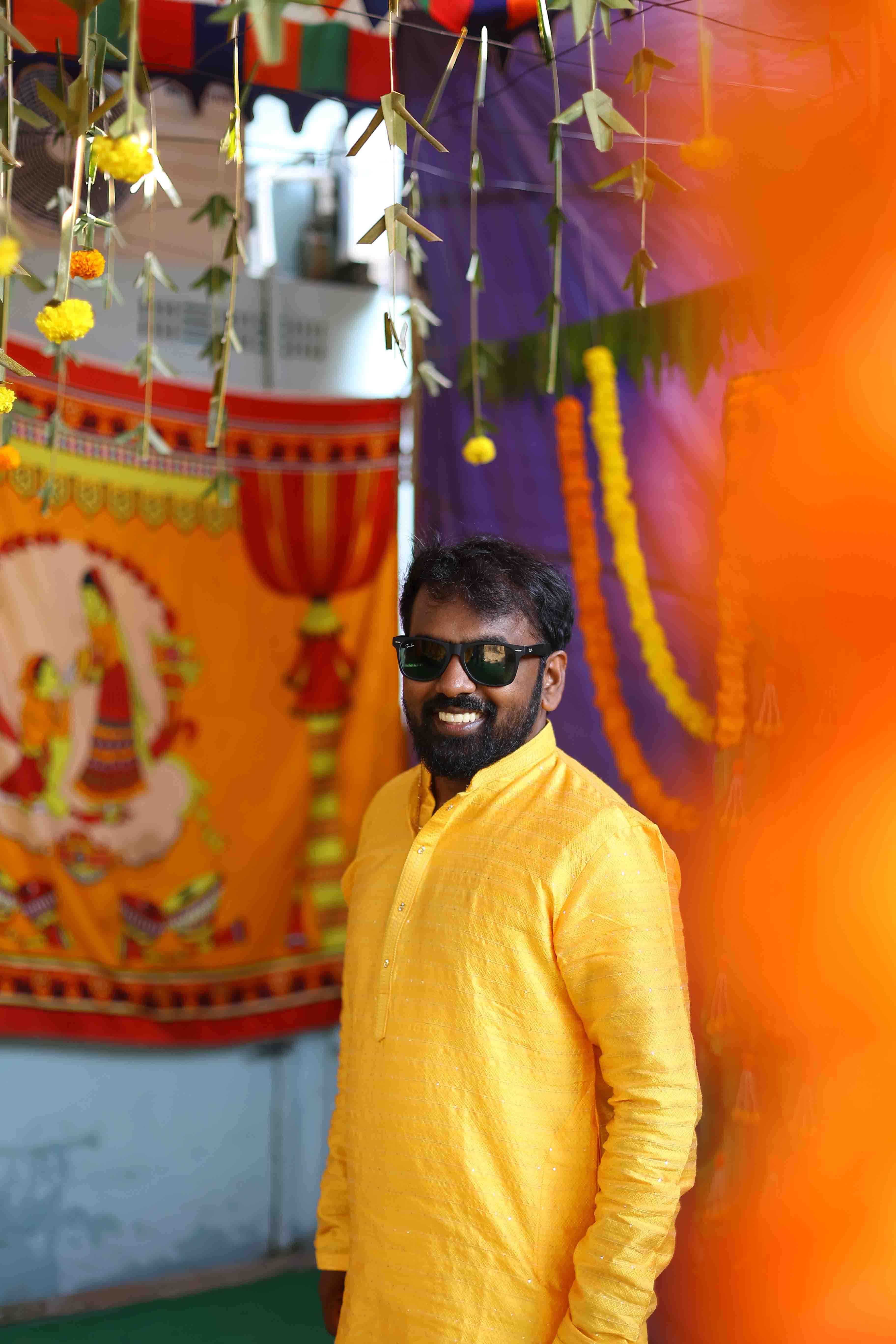 Anil wearing spectacles and smiling during the joyful haldi celebration