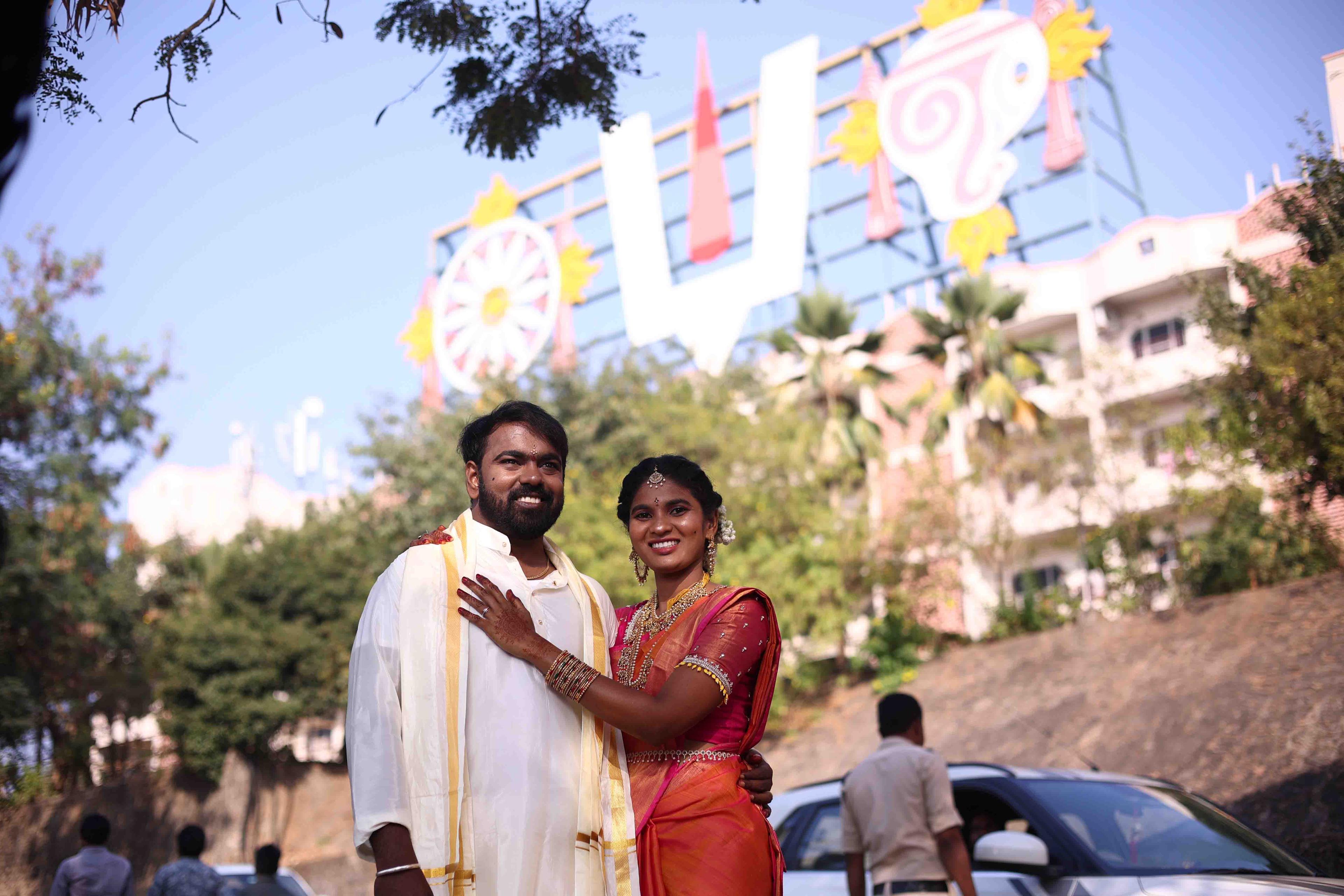 The couple posing gracefully beneath the sacred wedding venue entrance