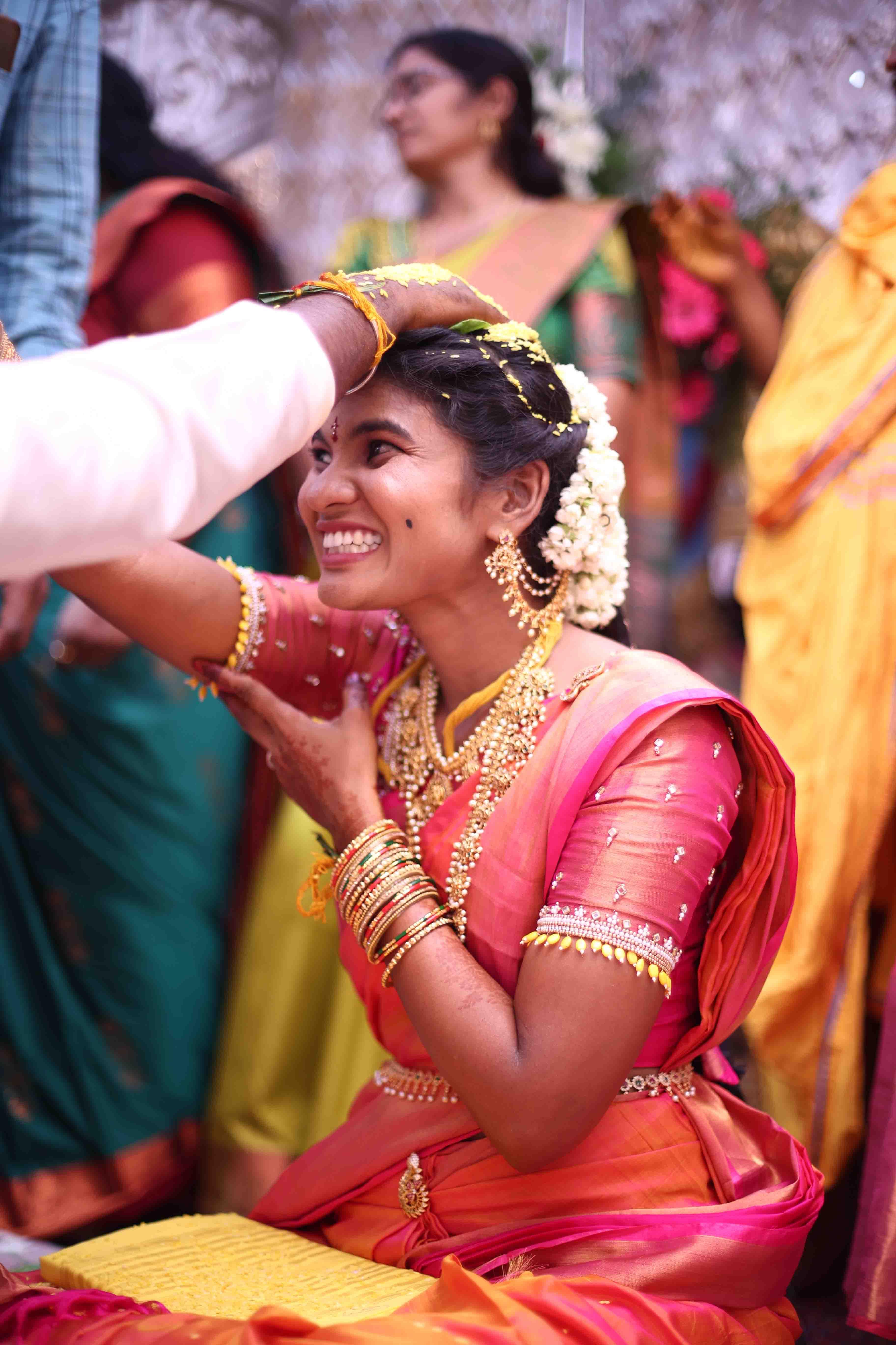Eswari smiling beautifully while sacred rituals are performed around her