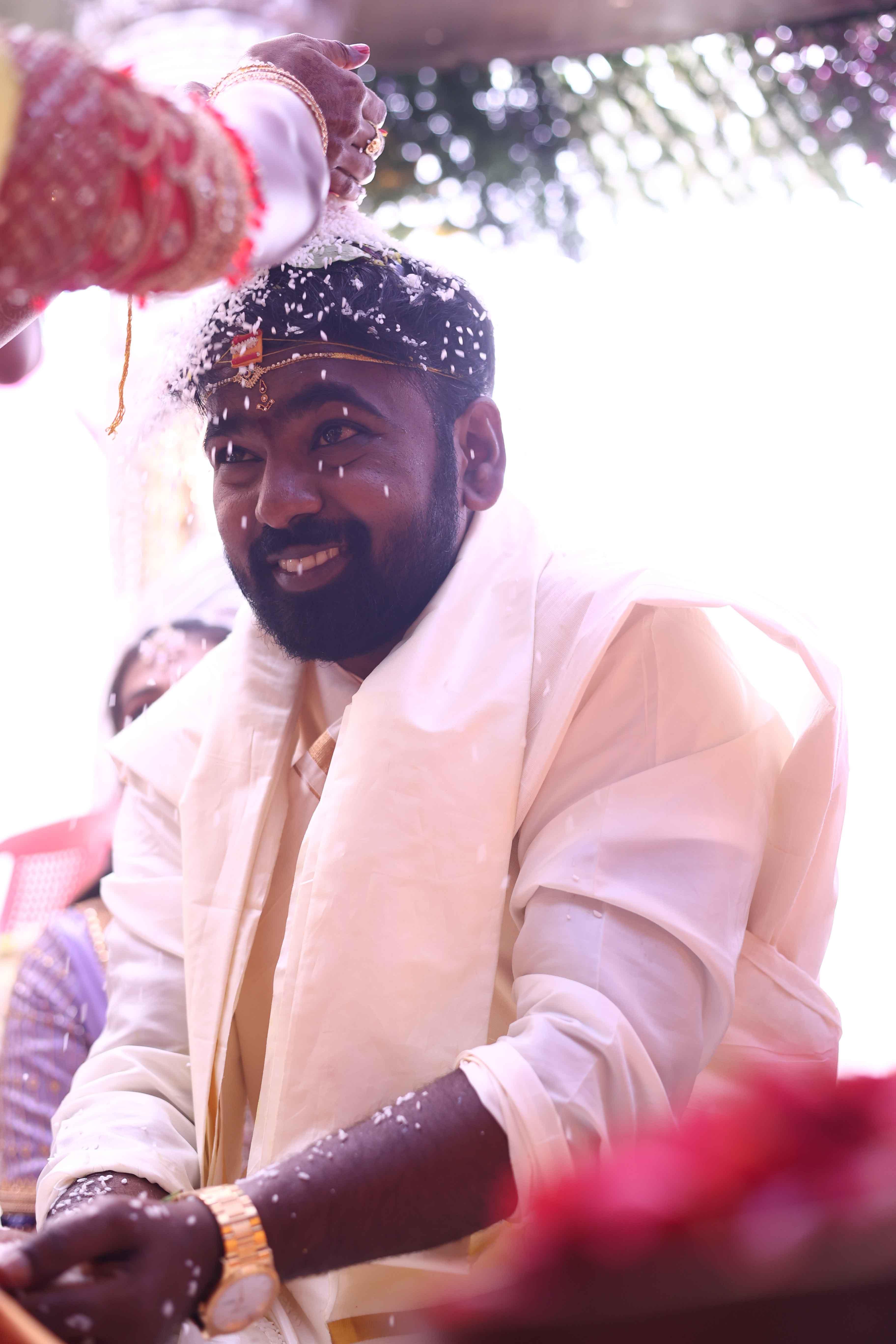 Anil smiling brightly during a joyful ritual moment of the wedding
